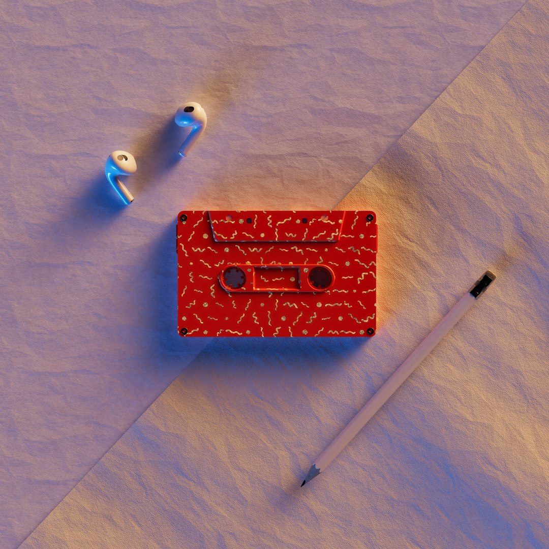 a red box with a cassette on top of it next to a pair of scissors