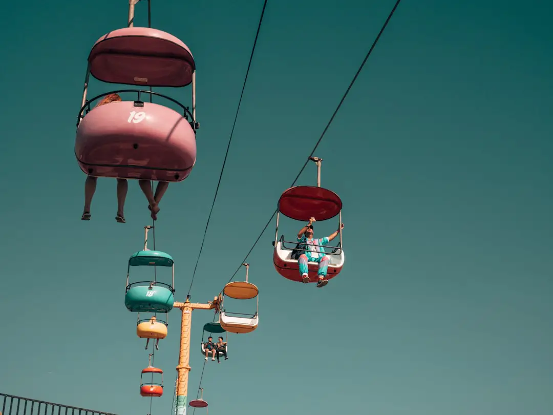 people on assorted-color cable cars at daytime