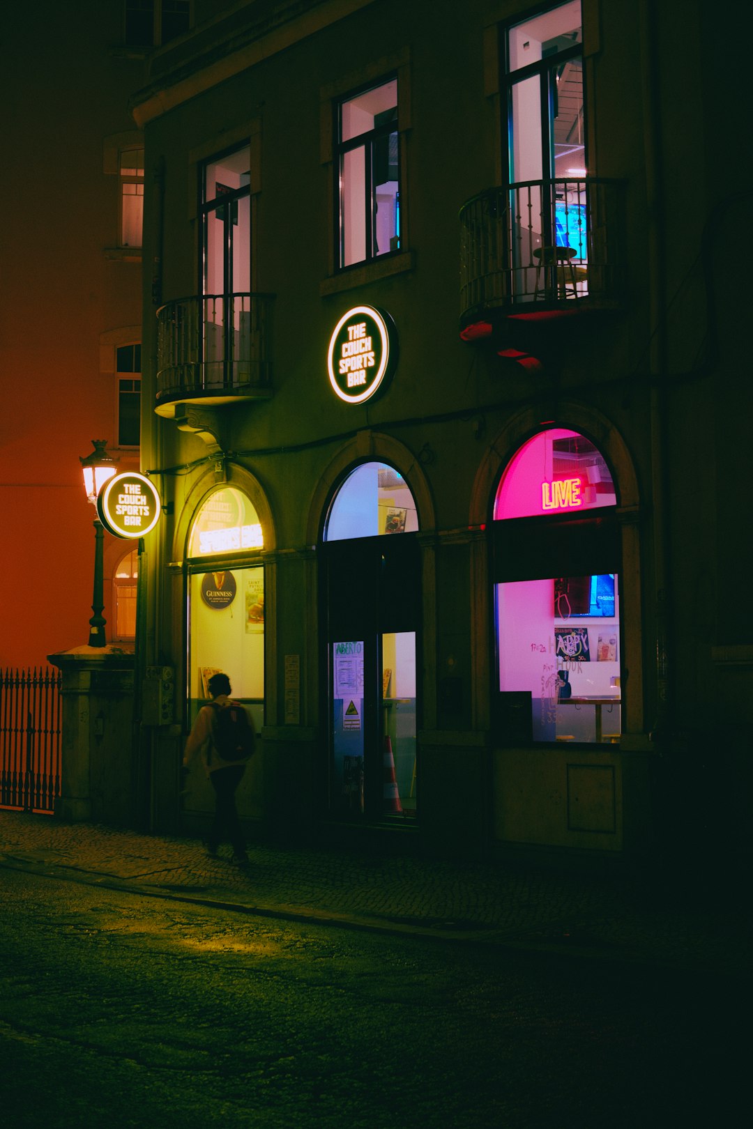 a person standing outside of a building at night