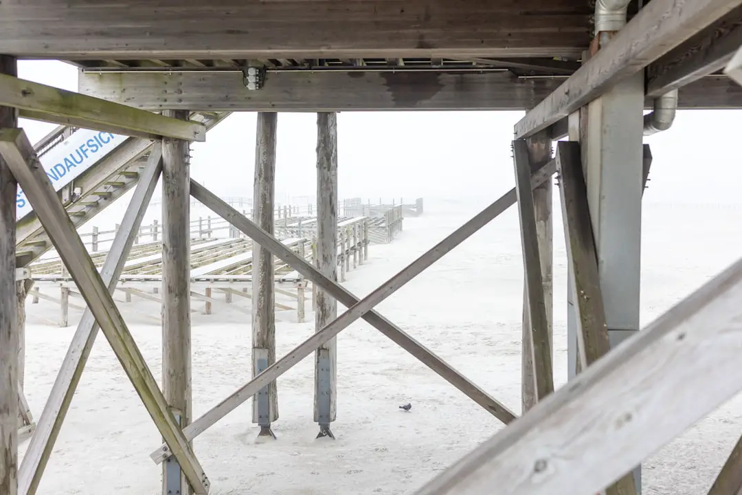 Wooden pier with foggy beach in background.