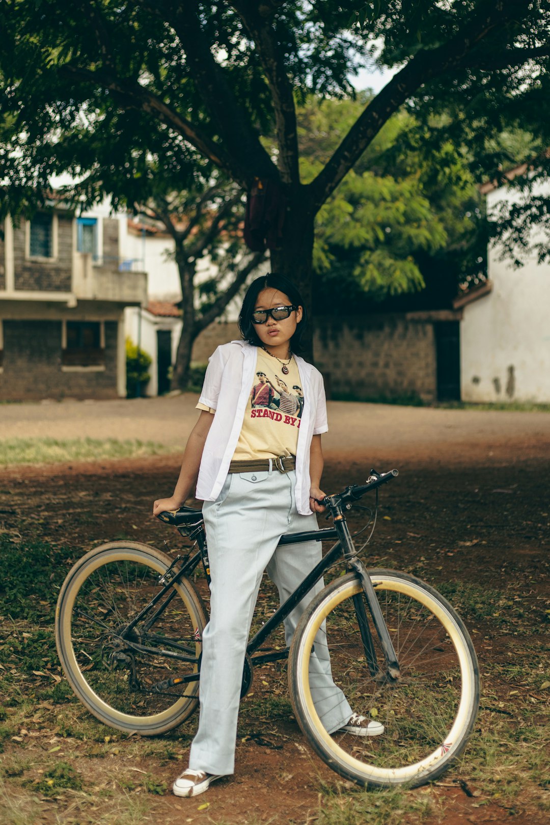 A woman standing next to a bike in a park